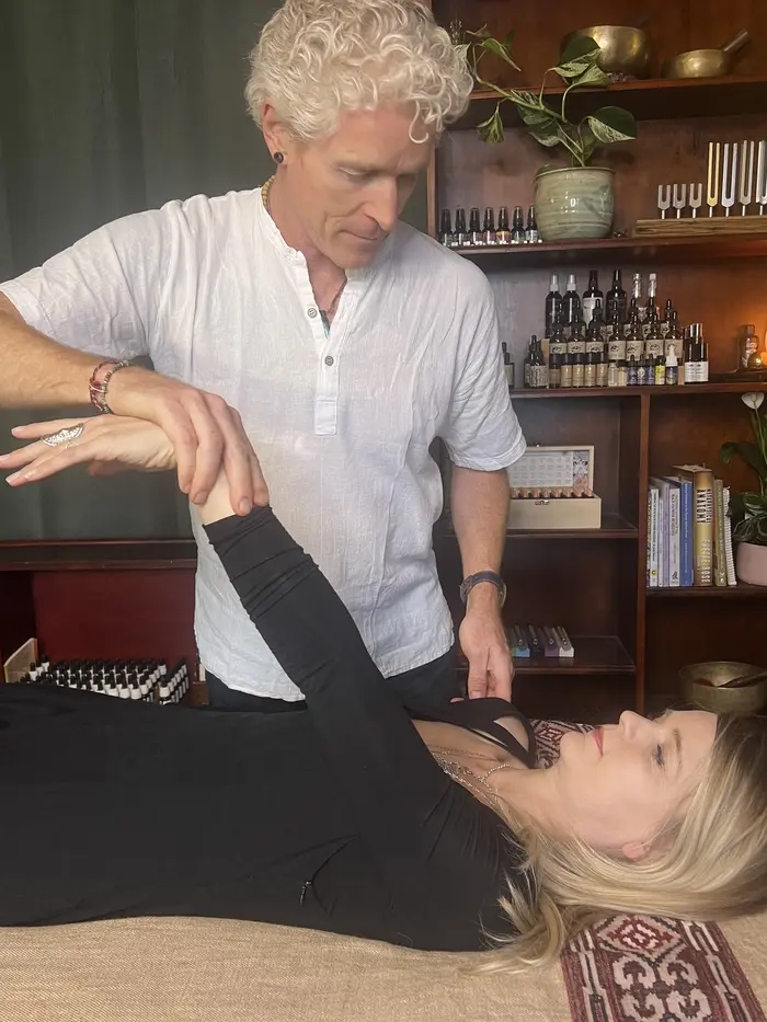 Phil testing a client's arm muscle during a kinesiology session